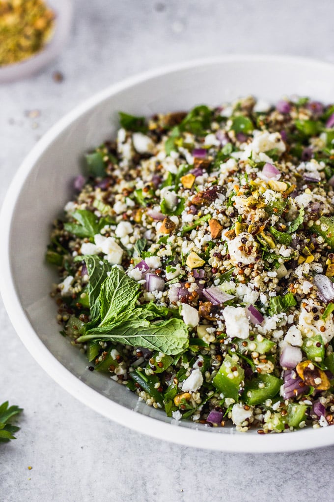 quinoa salad in white bowl with spoon by fork in the kitchen