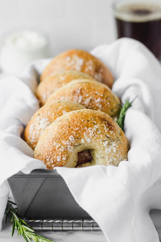 homemade rosemary bagels in pan with white linen
