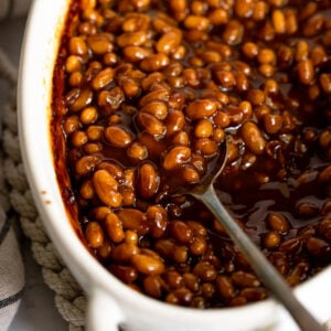 Baked beans in dish with spoon.