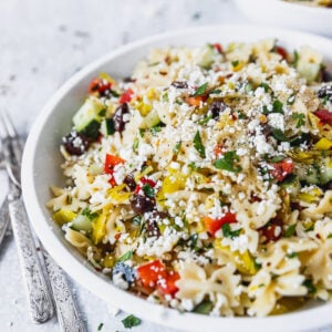 mediterranean pasta salad in white bowl with forks