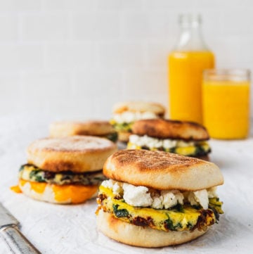 rows of breakfast sandwiches with knife and orange juice glasses