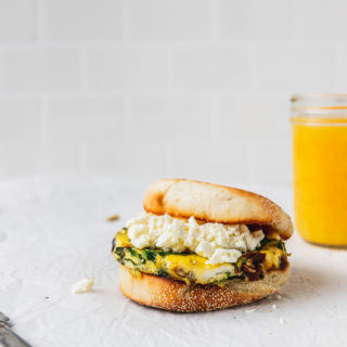 english muffin with egg and feta cheese next to orange juice
