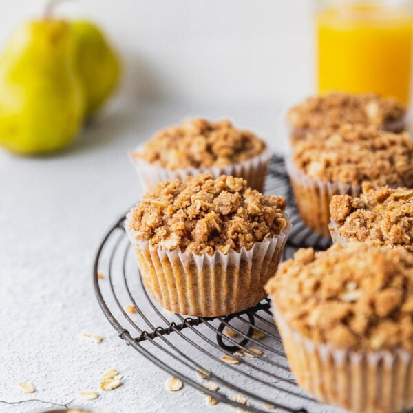 muffins on cooling rack with oats and whole pear