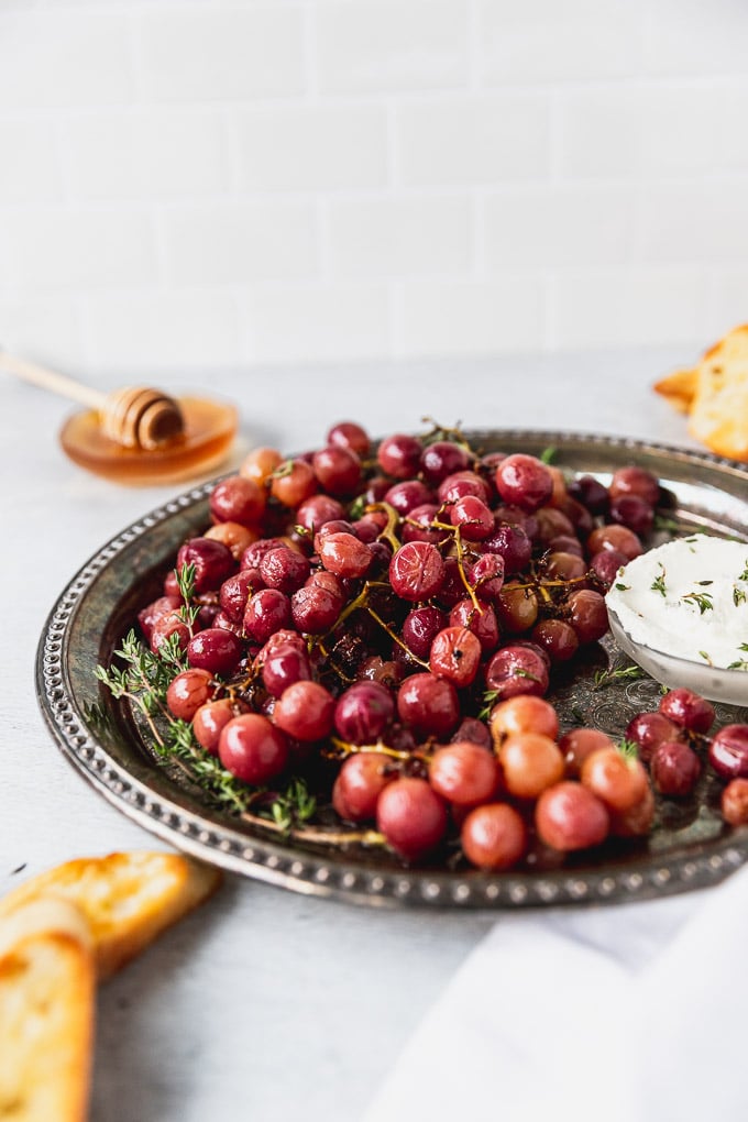 roasted grapes on platter with goat cheese and honey