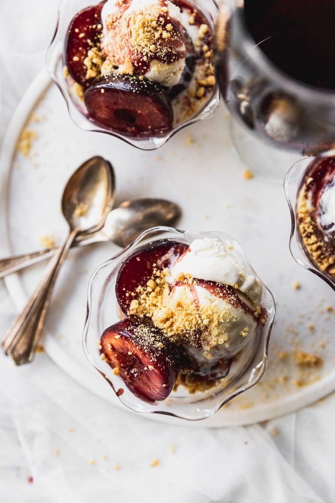 overhead bowls of sauteed plums with ice cream, shortbread cookies, and wine sauce