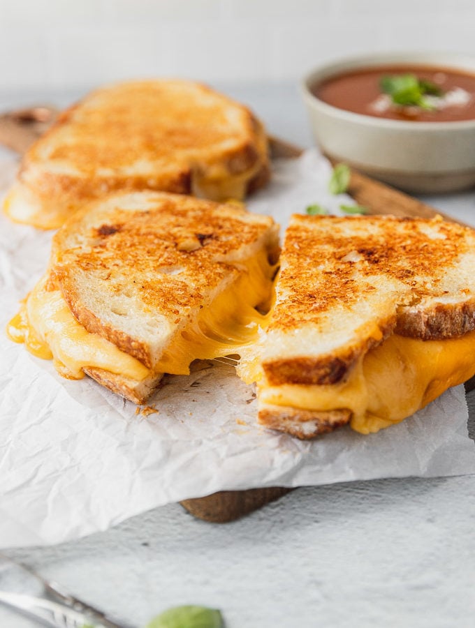 grilled cheese cup with cheese pull on a serving tray