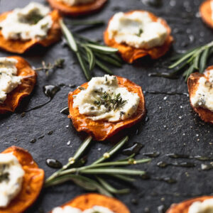 sweet potato with goat cheese on top of black serving tray from side