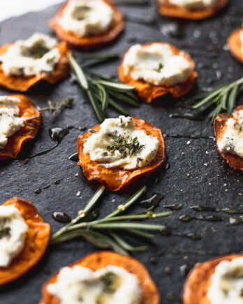 sweet potato with goat cheese on top of black serving tray from side