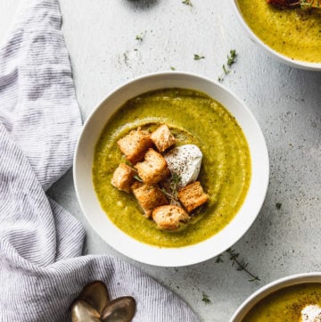 three bowls of broccoli soup with croutons