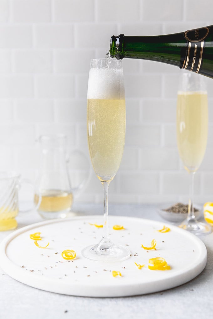 pouring champagne into lavender french 75