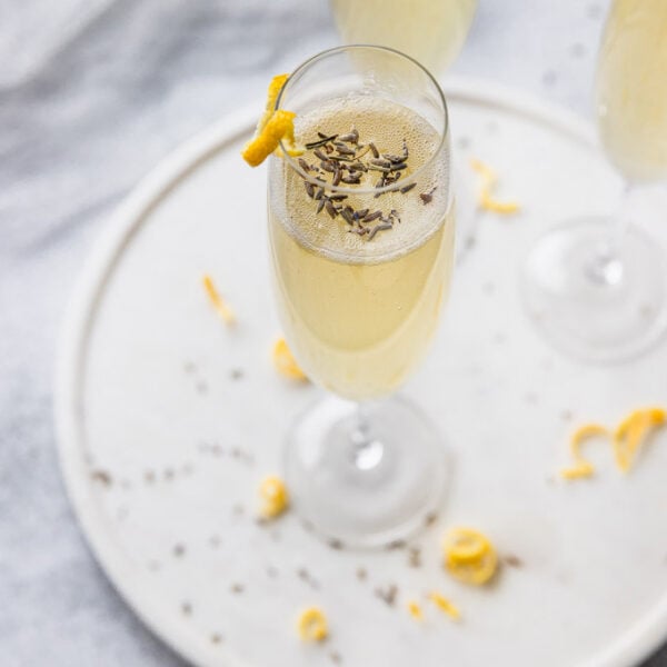 champagne flute with lavender flowers and french 75 with lemon twist