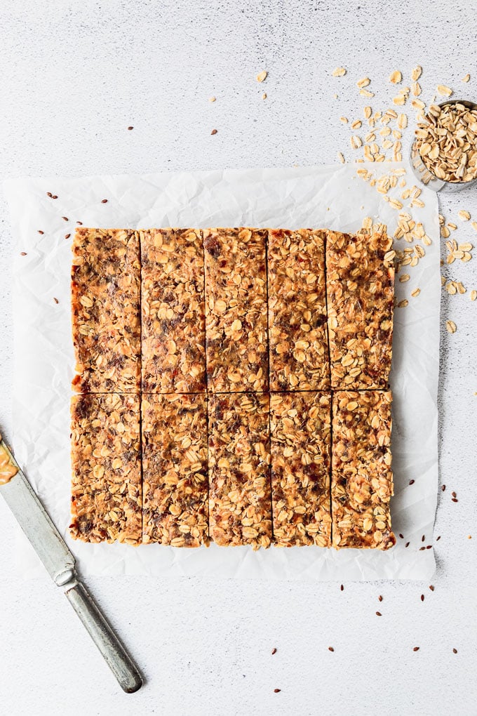 Sliced granola bars on parchment paper in rows.