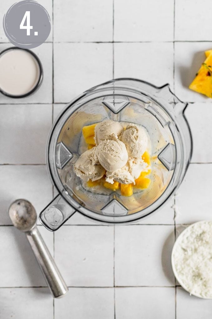 ice cream scoops in blender with pineapple for pina colada milkshake 