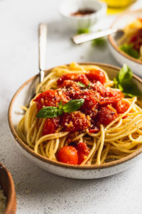 side view of cherry tomato sauce on pasta