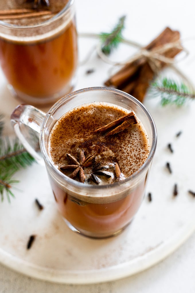 glass mug of spiced hot buttered rum with cinnamon stick