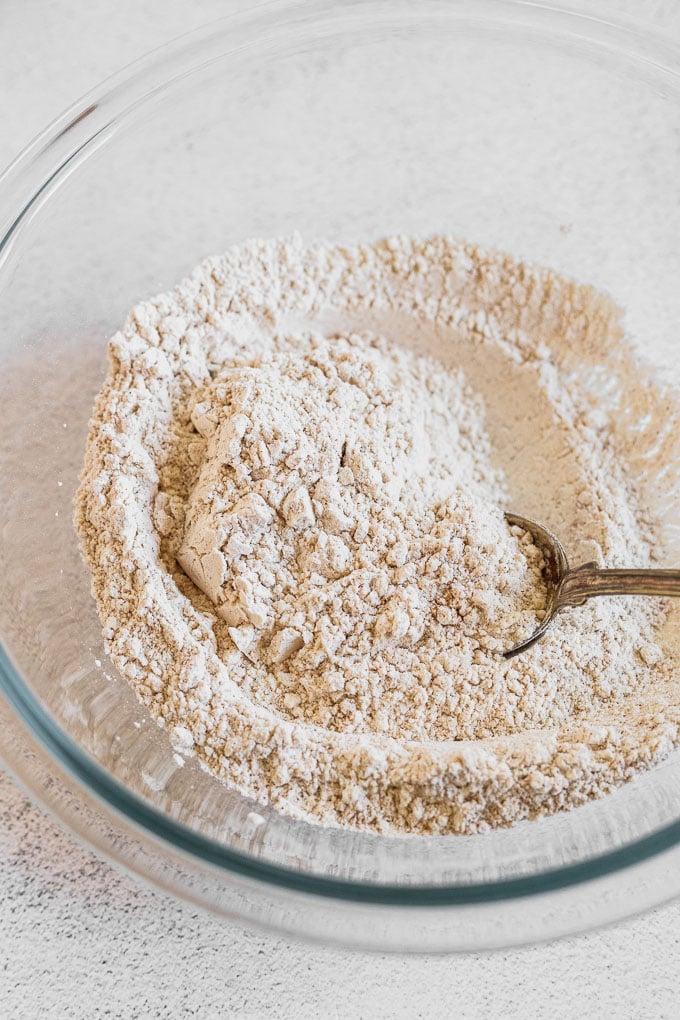 dry ingredients in glass mixing bowl with spoon