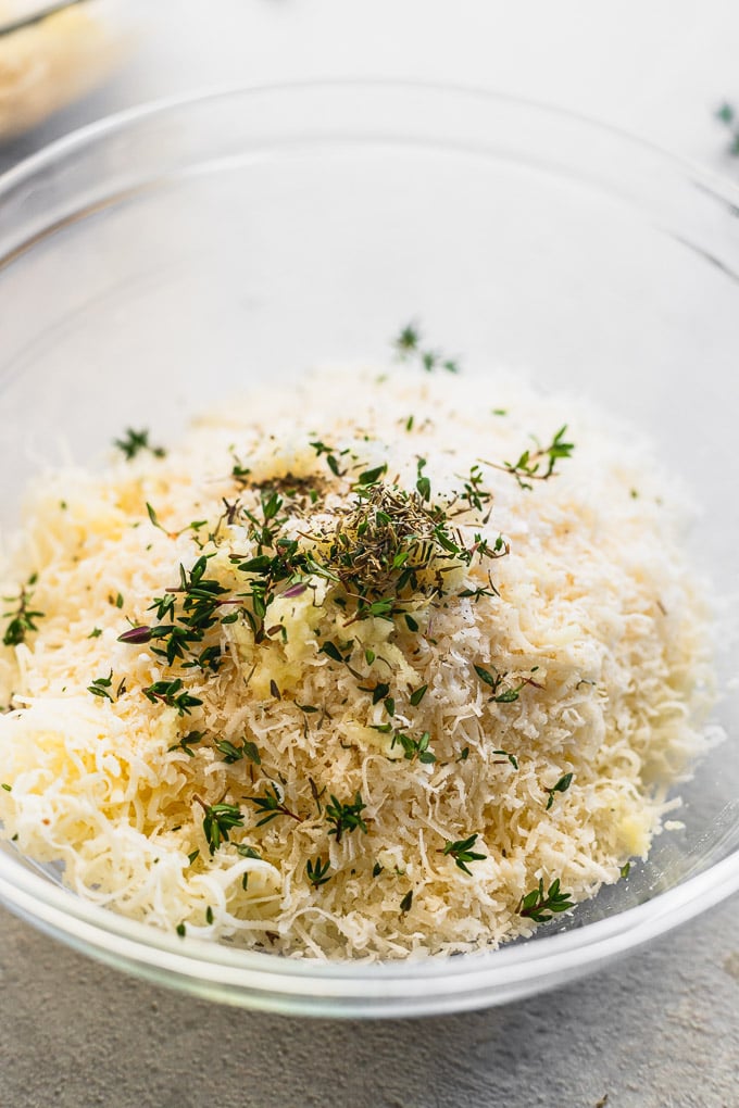 Bowl of shredded cheese and thyme.