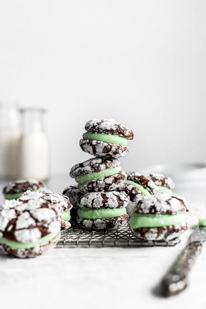 stack of chocolate mint sandwich cookies with milk in background
