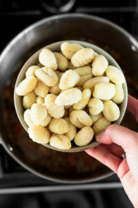 Bowl of dried gnocchi over pan.