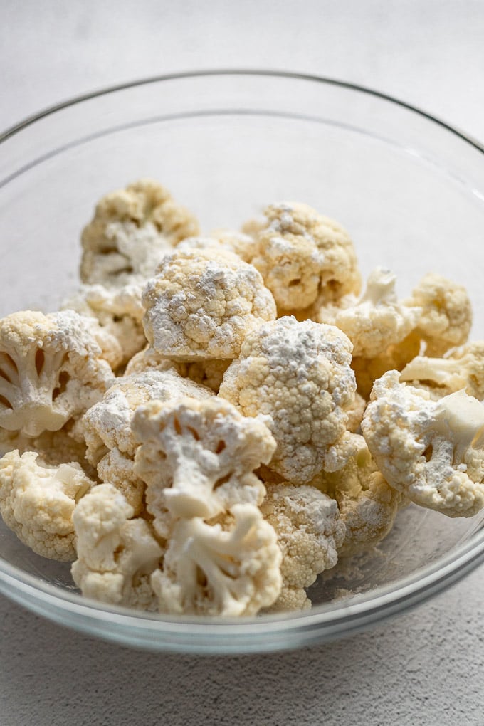Bowl of cauliflower florets tossed in corn starch.