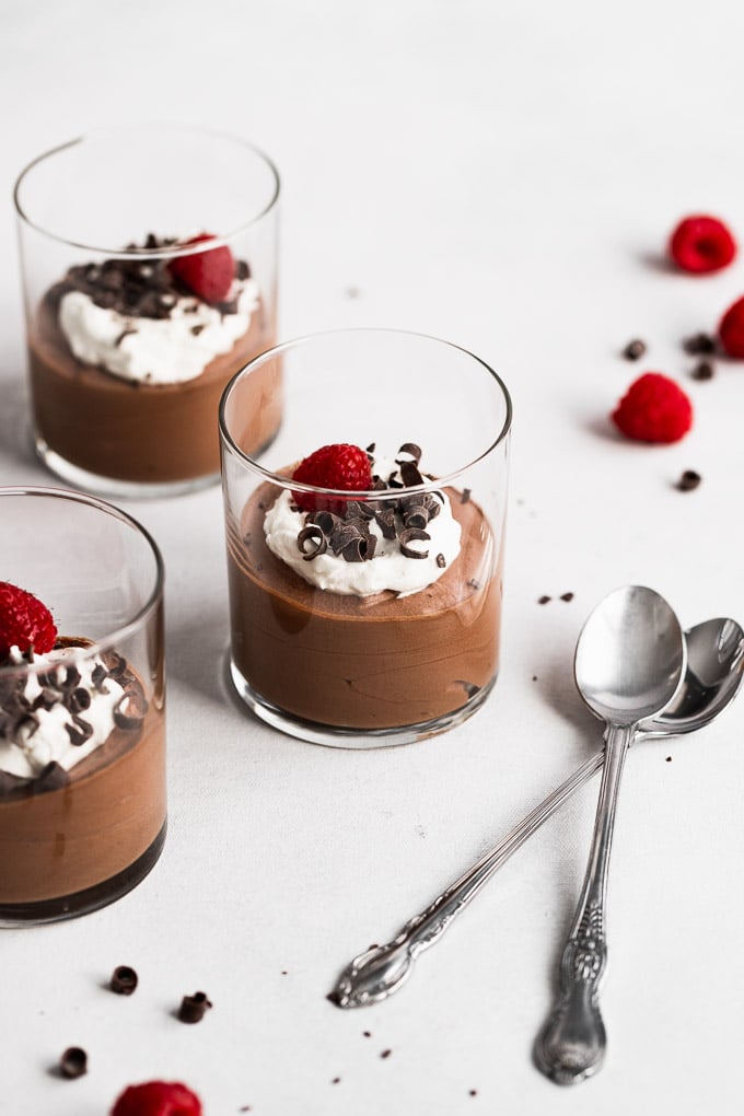 dark chocolate mousse in glasses with raspberry on top