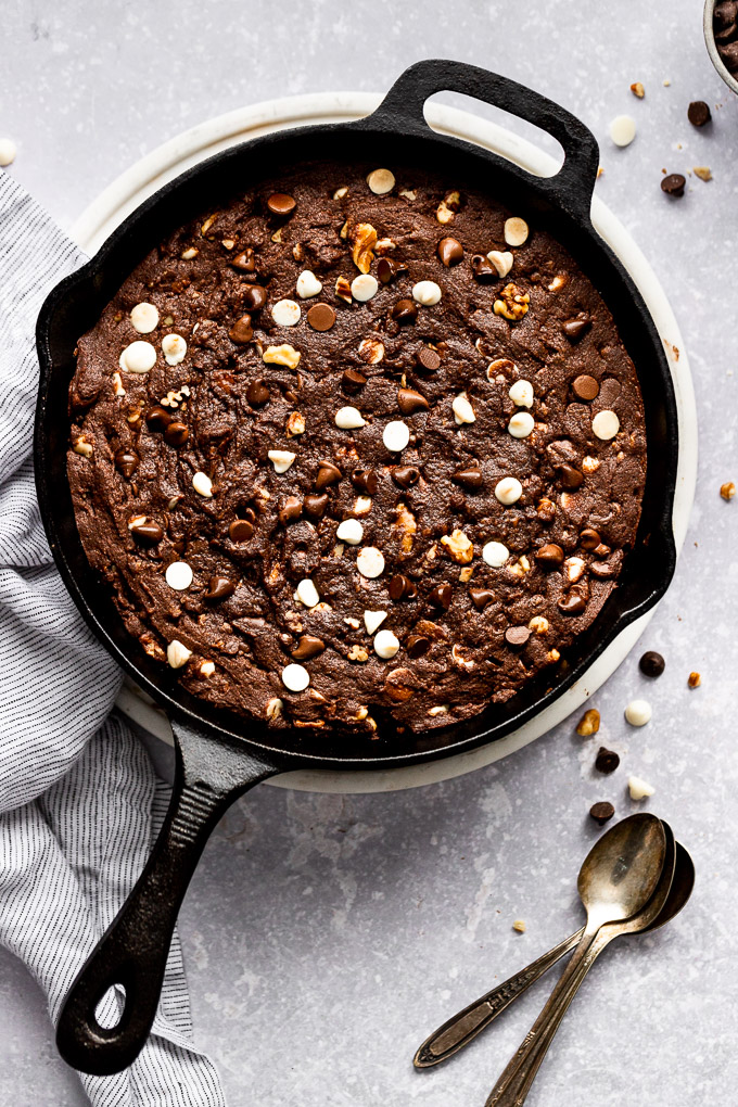 triple chocoalte skillet cookie with linen and spoons next to it