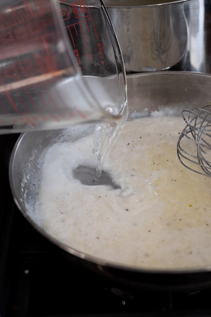 Pasta water pouring into cream sauce.