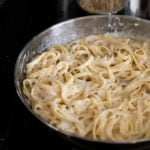 Fettuccine in skillet with sauce.