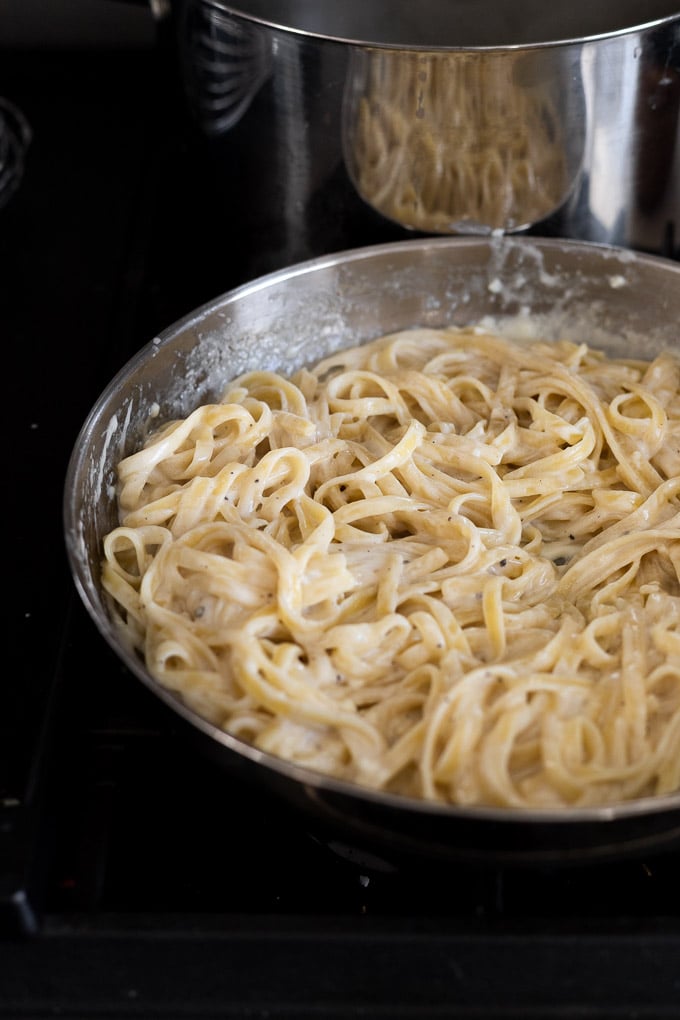 Fettuccine in skillet with sauce.