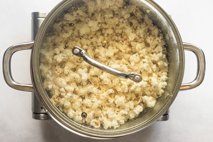 Lid on pot with popped popcorn inside.