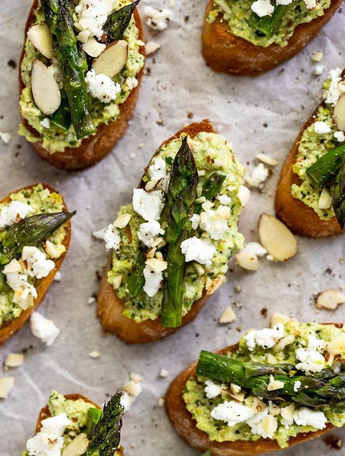 Overhead citrus pesto crostini scattered next to each other.