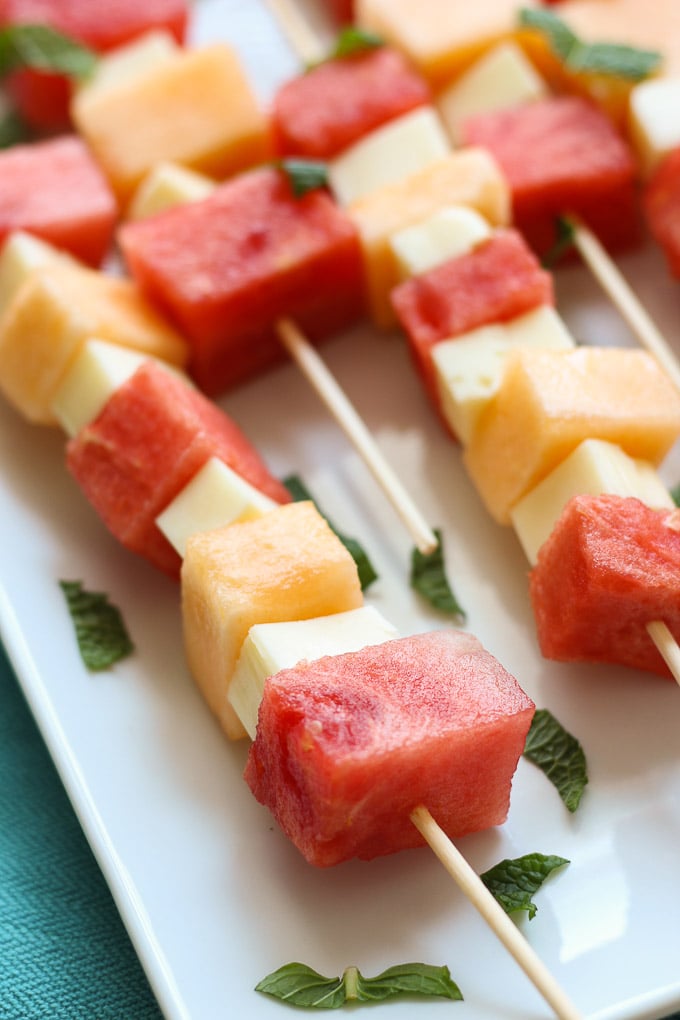 Skewers of melon and watermelon with cheese and mint.
