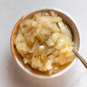 Bowl of caramelized onions with spoon.