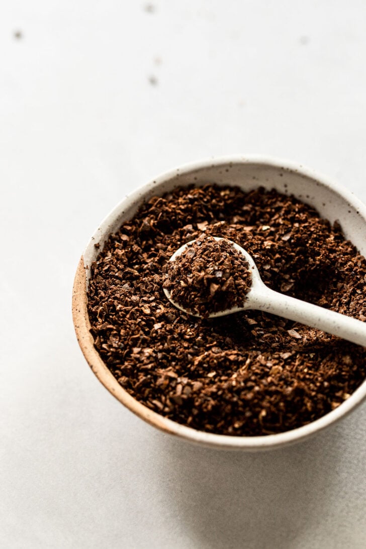 Bowl of coffee grounds with spoon.