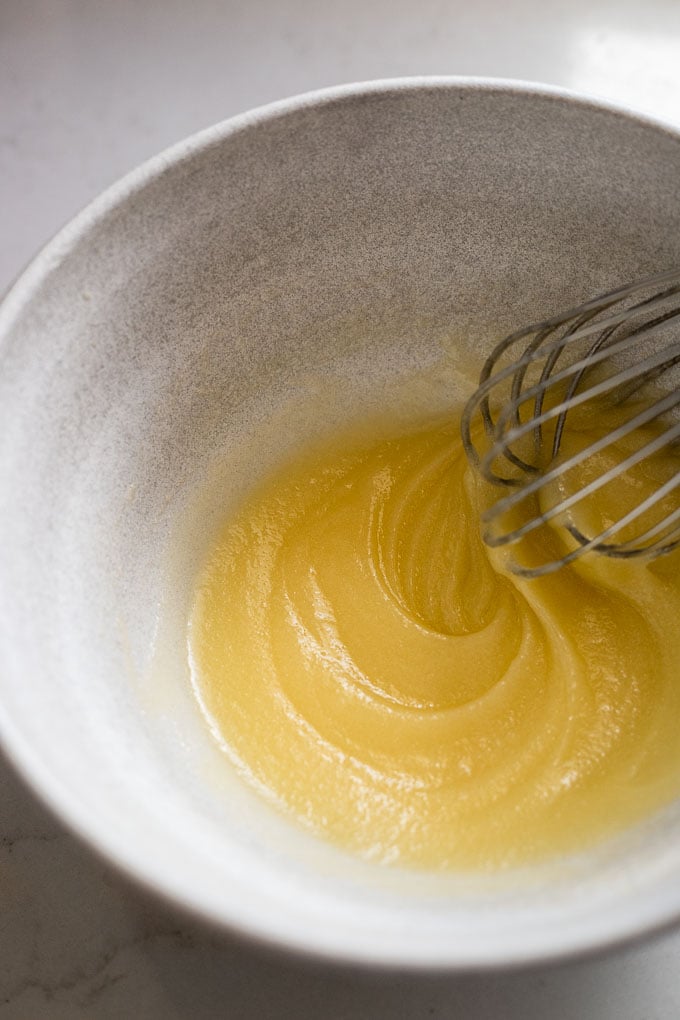 Sugar and butter whisked in bowl.