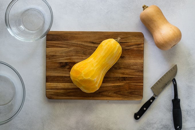 Peeled butternut squash on cutting board.