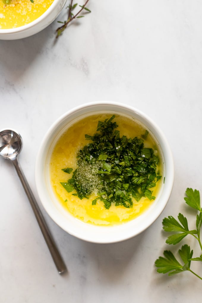 Bowl of melted butter with parsley.