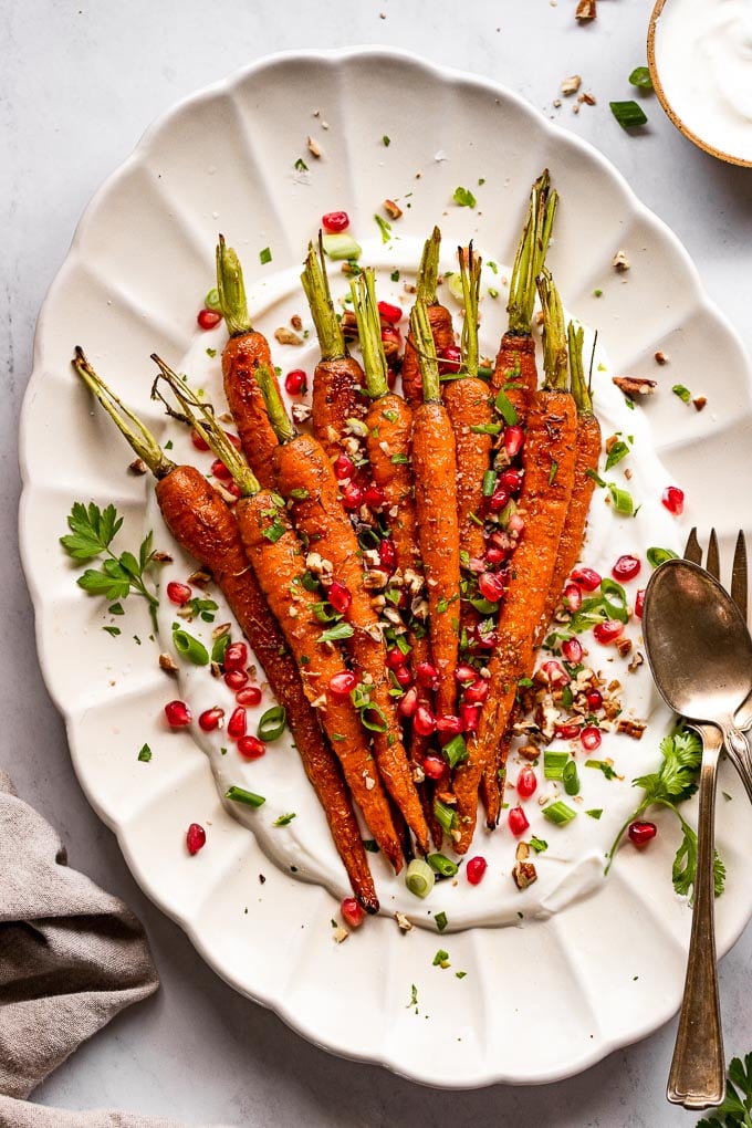 Roasted carrots on serving tray with toppings.