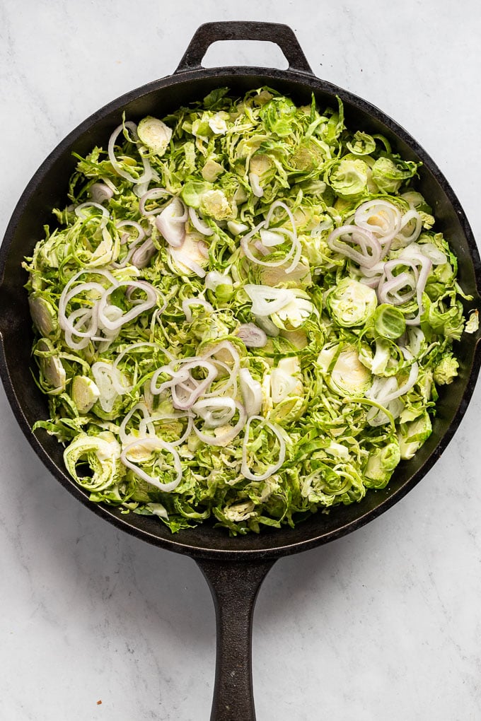Raw shredded brussels sprouts in skillet.