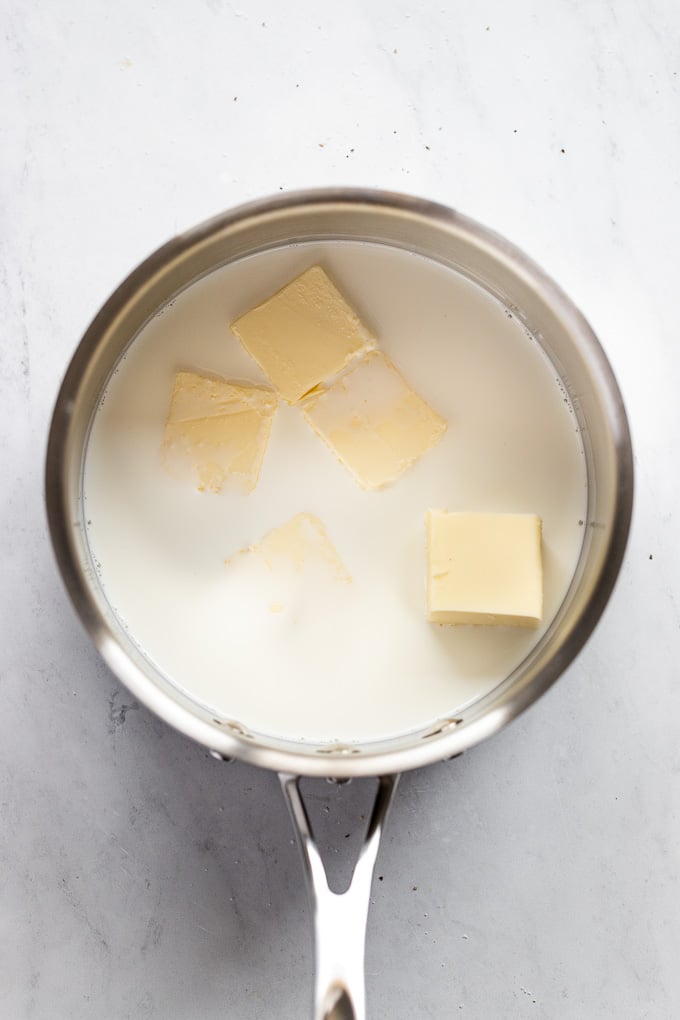 Pot with milk and pats of butter.