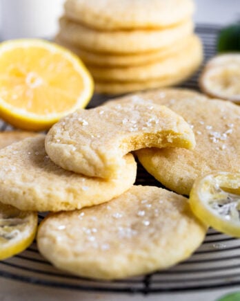 Stack of lemon sugar cookies one with a bite out.