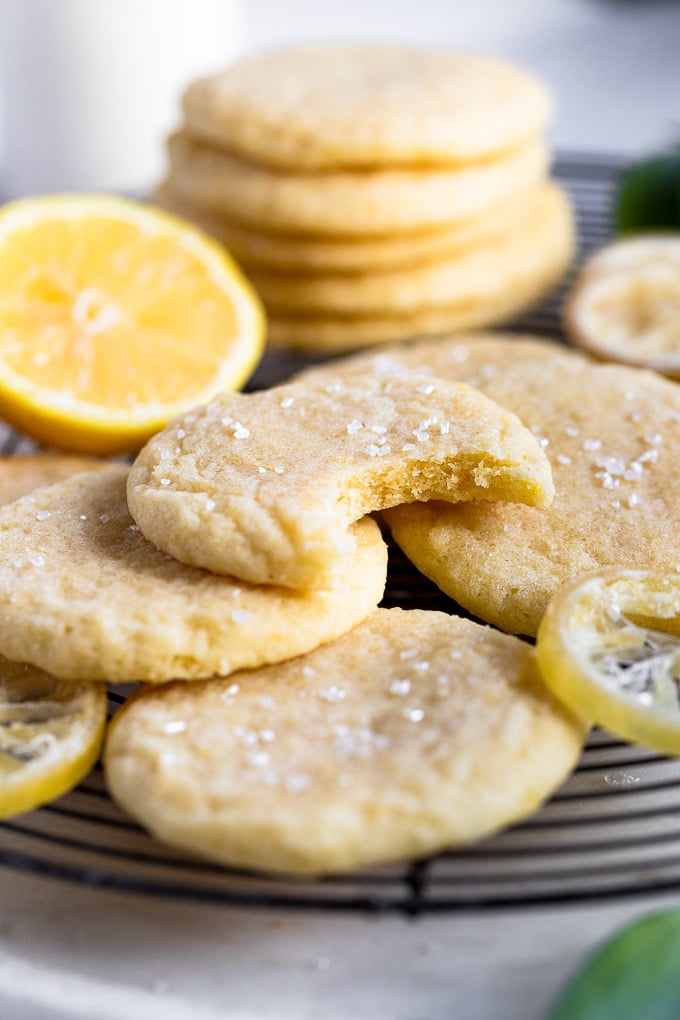 Stack of lemon sugar cookies one with a bite out.