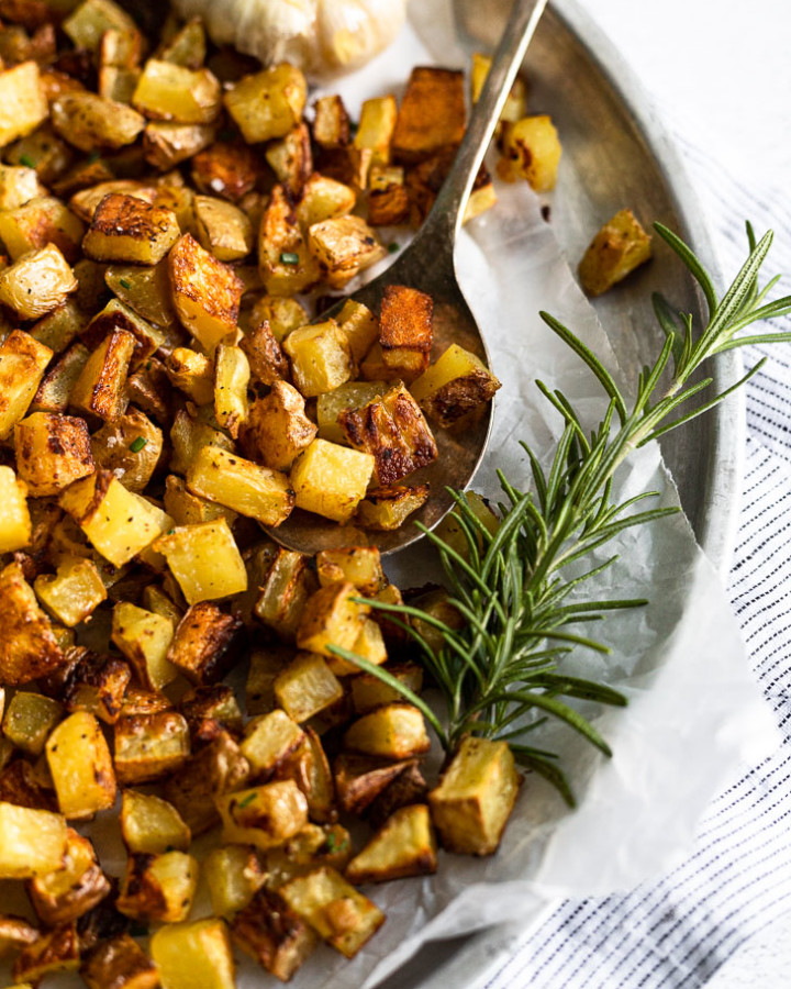 Tray of diced potatoes with rosemary.
