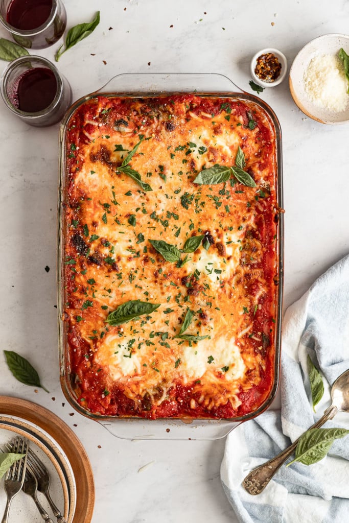 Casserole pan with baked spaghetti garnished with basil.