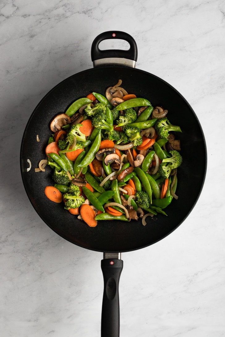 Wok with snap peas, broccoli, and carrots.
