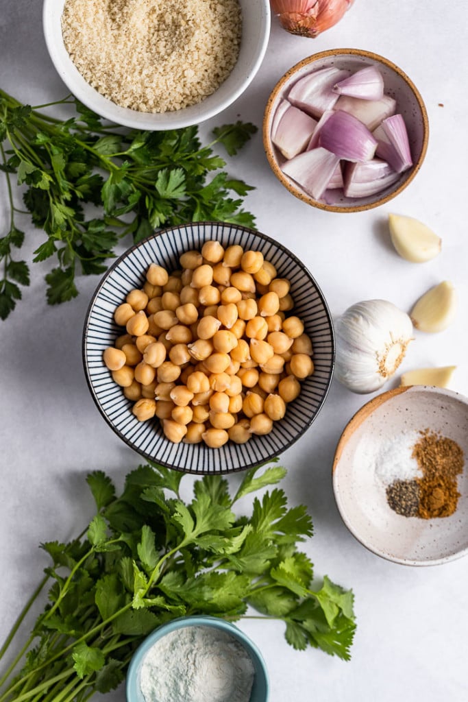 Ingredients in bowls: chickpeas, spices, panko, shallot, garlic, and flour.