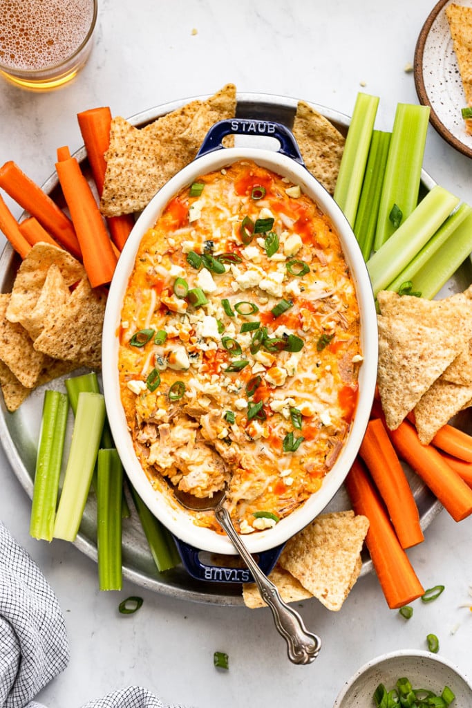 Buffalo dip on tray with chips, carrots, and celery.