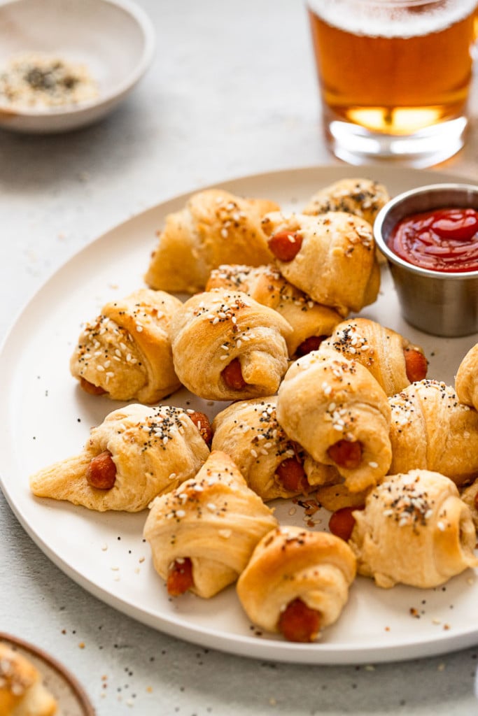 Side view of pigs in a blanket on a plate.