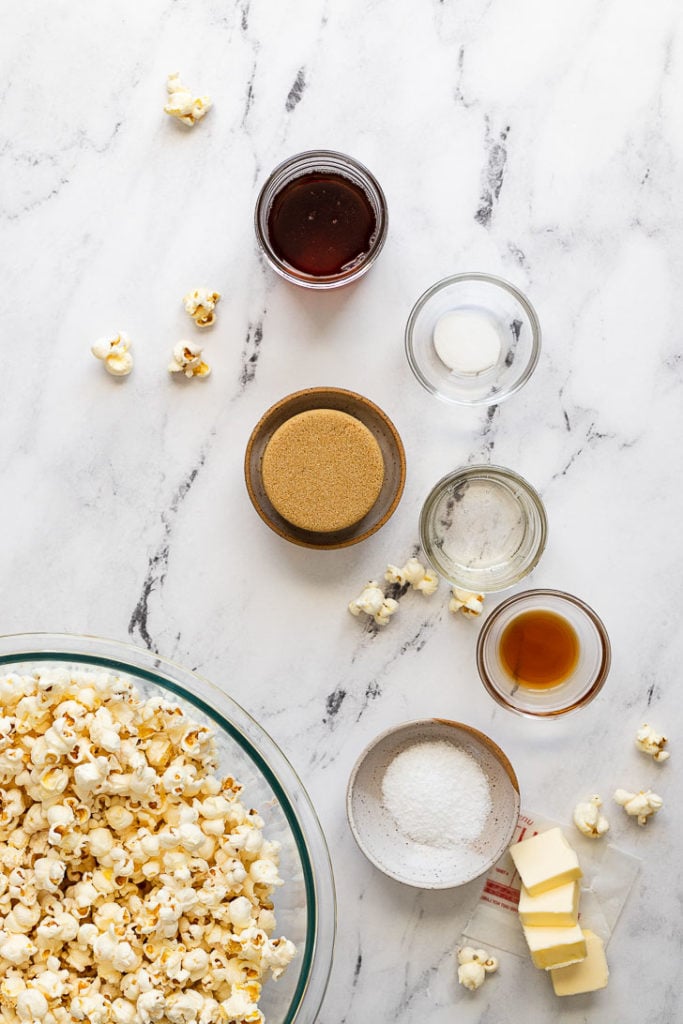 Bowls of ingredients next to popcorn in bowl.