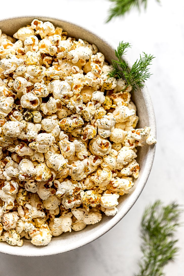 Half bowl with popcorn and fresh dill.